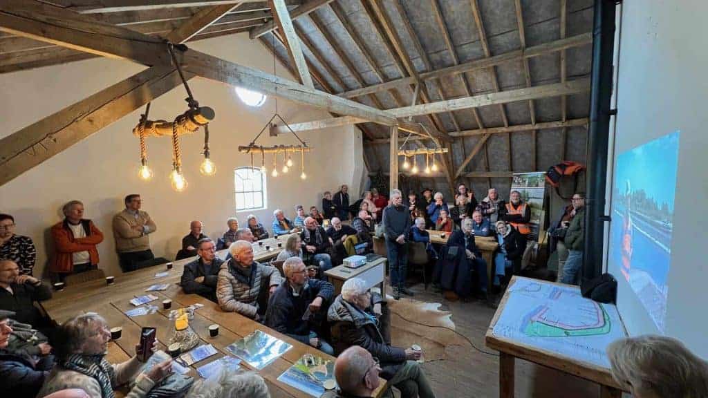 Gezellige bijeenkomst in een sfeervolle zaal op 't Gelders Eiland met mensen die naar een presentati.