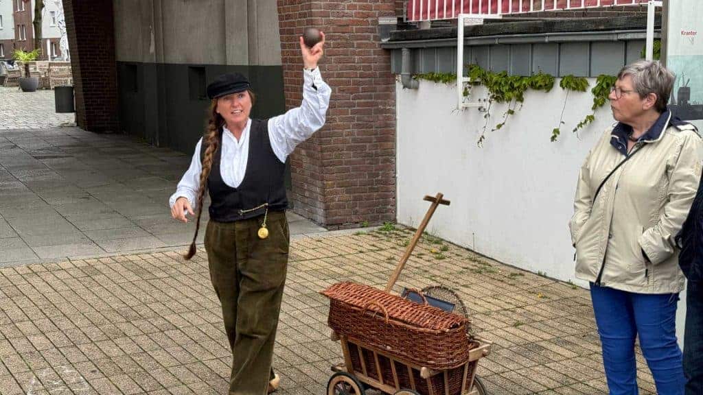 Hulde aan een straatartiest op 't Gelders Eiland met een mand en stok, die een levendige performance.
