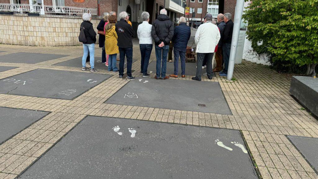 Hondenuitlaatplek op 't Gelders Eiland met voetafdrukken en groep mensen in de achtergrond.