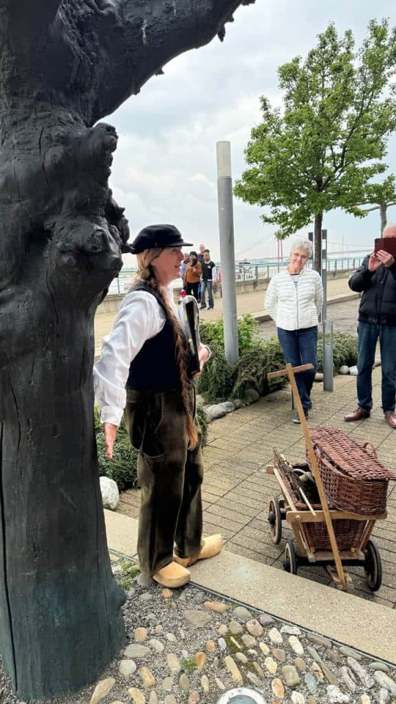 Gezellige straatmuzikant op 't Gelders Eiland met publiek en historische sfeer.