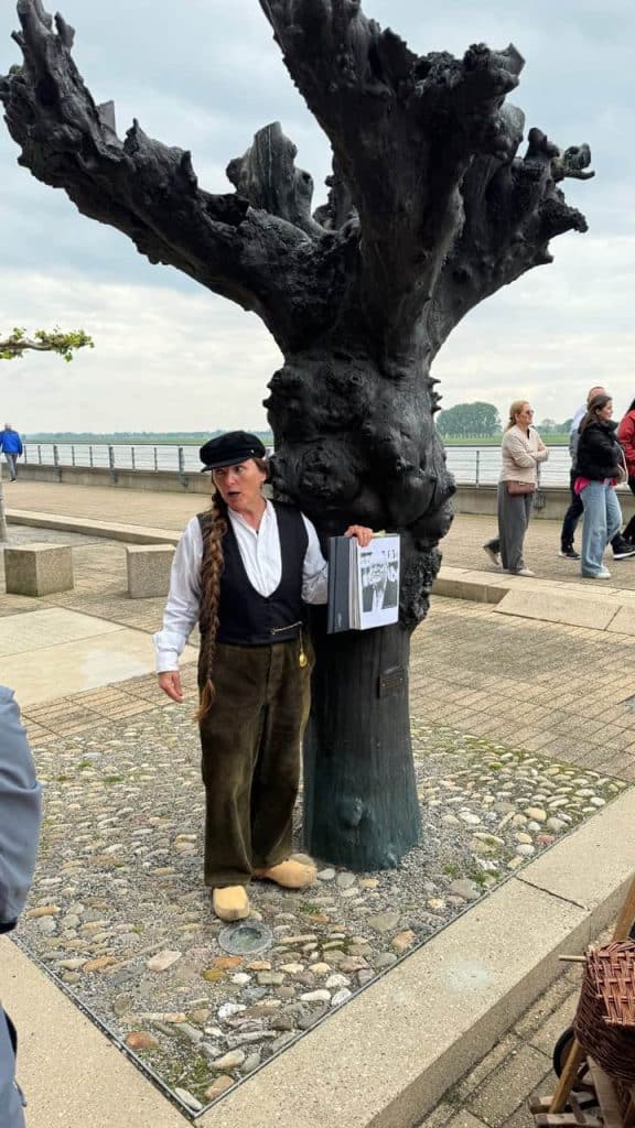 Een oude, knoestige boom op 't Gelders Eiland met mensen die ervan genieten.