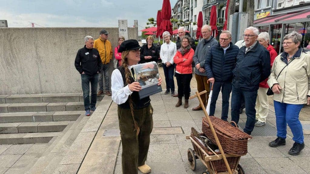 Hollandse gids vertelt geschiedenis aan groep toeristen op 't Gelders Eiland.