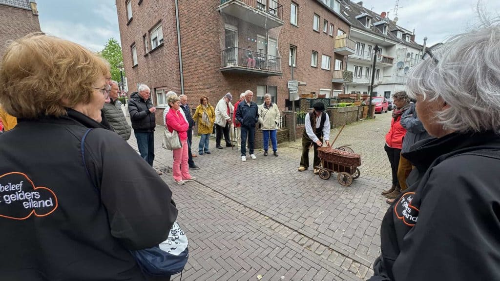 Deelnemers luisteren naar gids op 't Gelders Eiland tijdens een rondleiding.