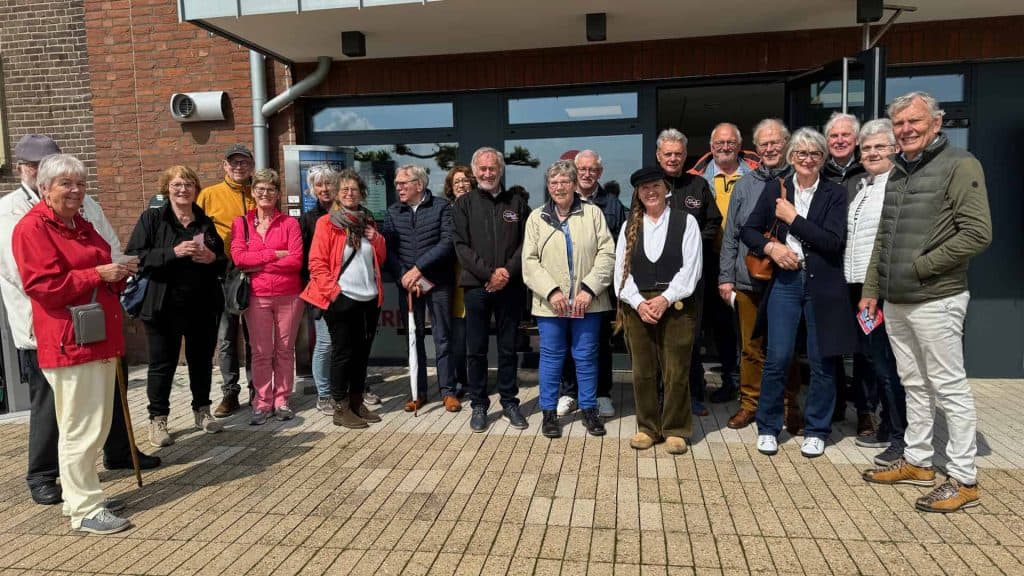 Gezelschap van mensen voor 't Gelders Eiland, groepsfoto bij het gebouw.