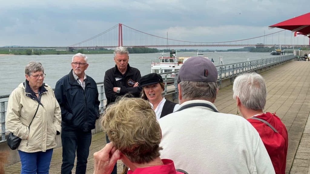 Groepswandeling langs de rivier met uitzicht op de brug op 't Gelders Eiland.
