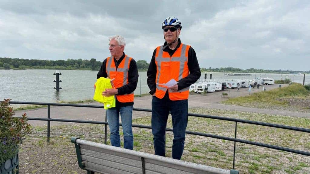 Haven op 't Gelders Eiland met twee mensen in veiligheidsvesten, uitzicht op rivier en boten.