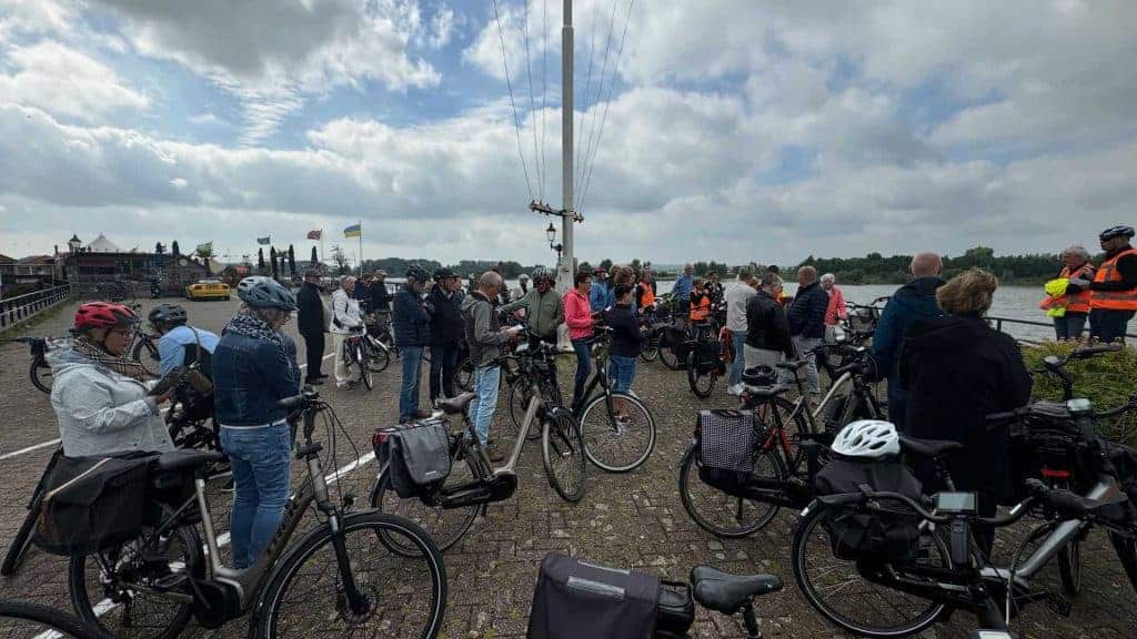Fietsen en mensen bij haven op 't Gelders Eiland, genieten van het uitzicht en de omgeving.