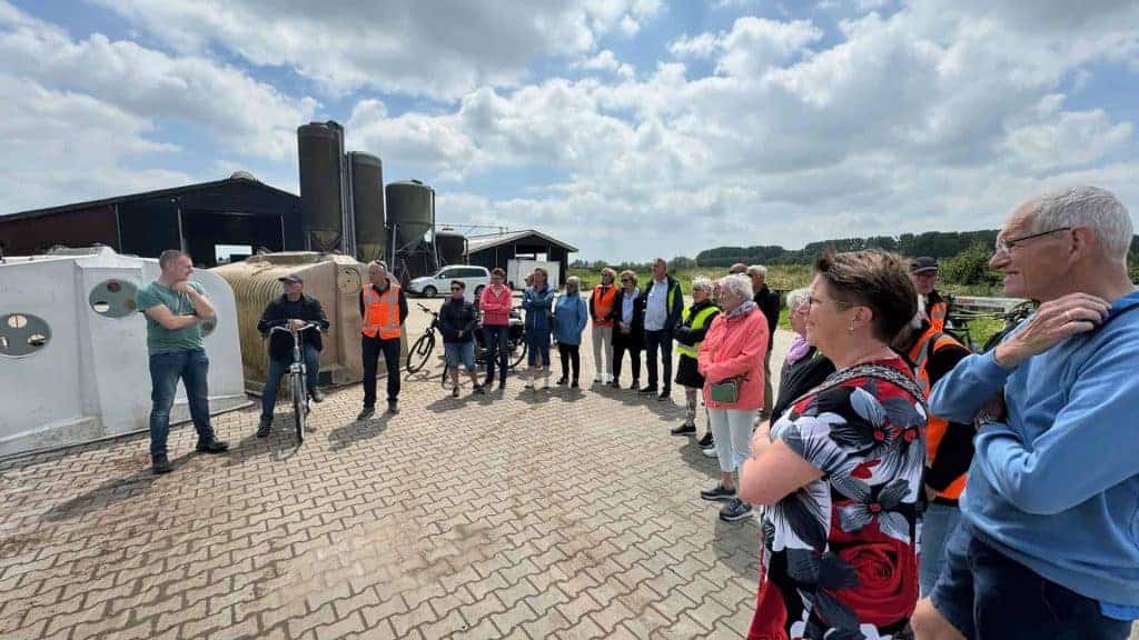 Haven op 't Gelders Eiland met groep toeristen en gids in openlucht.