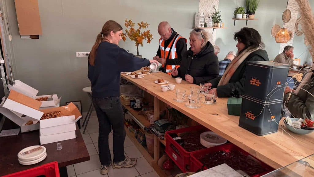 Gezellige koffiebar op 't Gelders Eiland met klanten en barista in gesprek.
