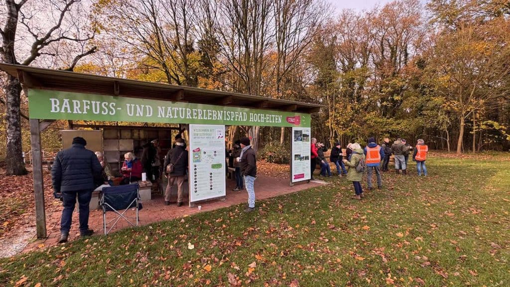 Gezellige informatiehut op 't Gelders Eiland met bezoekers en herfstbos op de achtergrond.