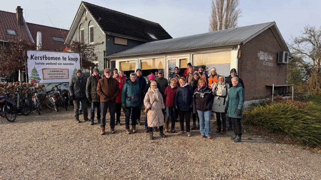 Kerkgebouw op 't Gelders Eiland met groep mensen voor een kerstbomenactie.