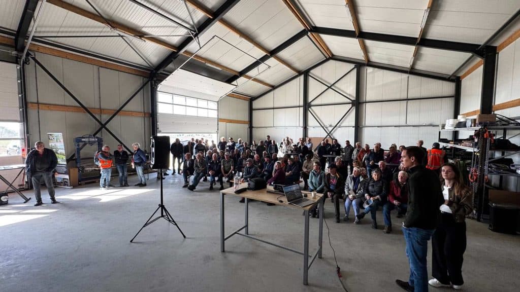 Gezellige bijeenkomst in een grote loods op 't Gelders Eiland met veel bezoekers en sprekers.