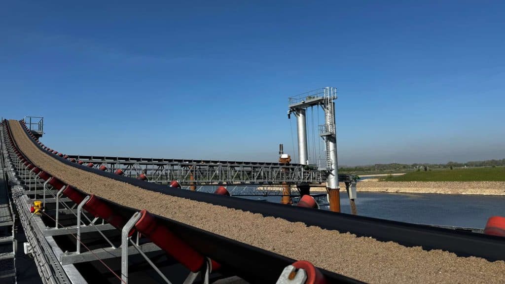 Transportband op 't Gelders Eiland met zand en water, industriële omgeving.
