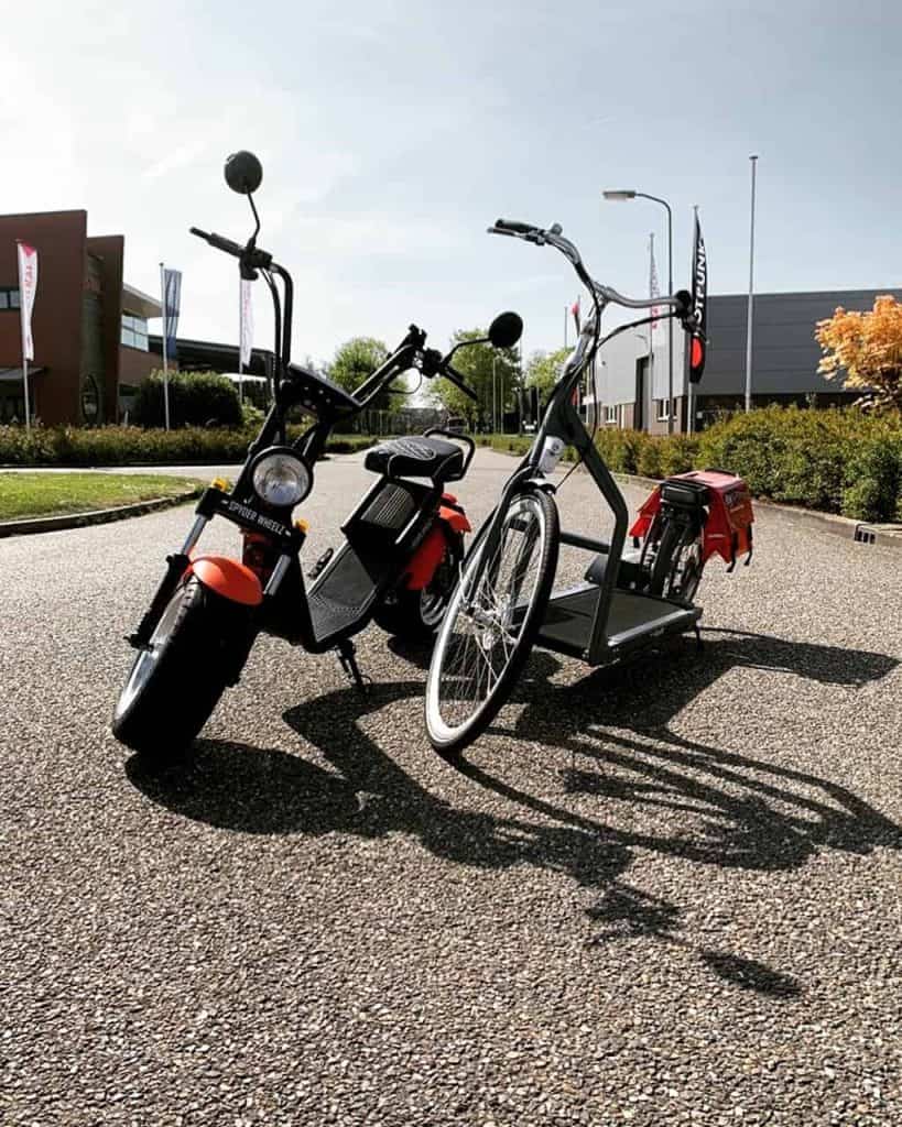 Elektrische bakfiets en scooter op straat in Arnhem, Gelderland.