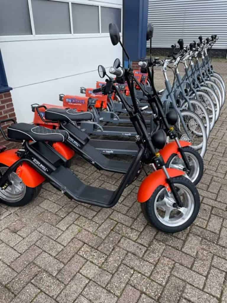 E-bikes en scooters geparkeerd buiten bij 't Gelders Eiland, ideaal voor verkenning.