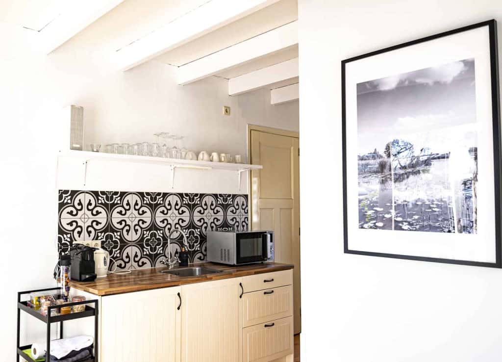 Kleine keuken met zwart-wit decor en foto aan de muur in een modern interieur.