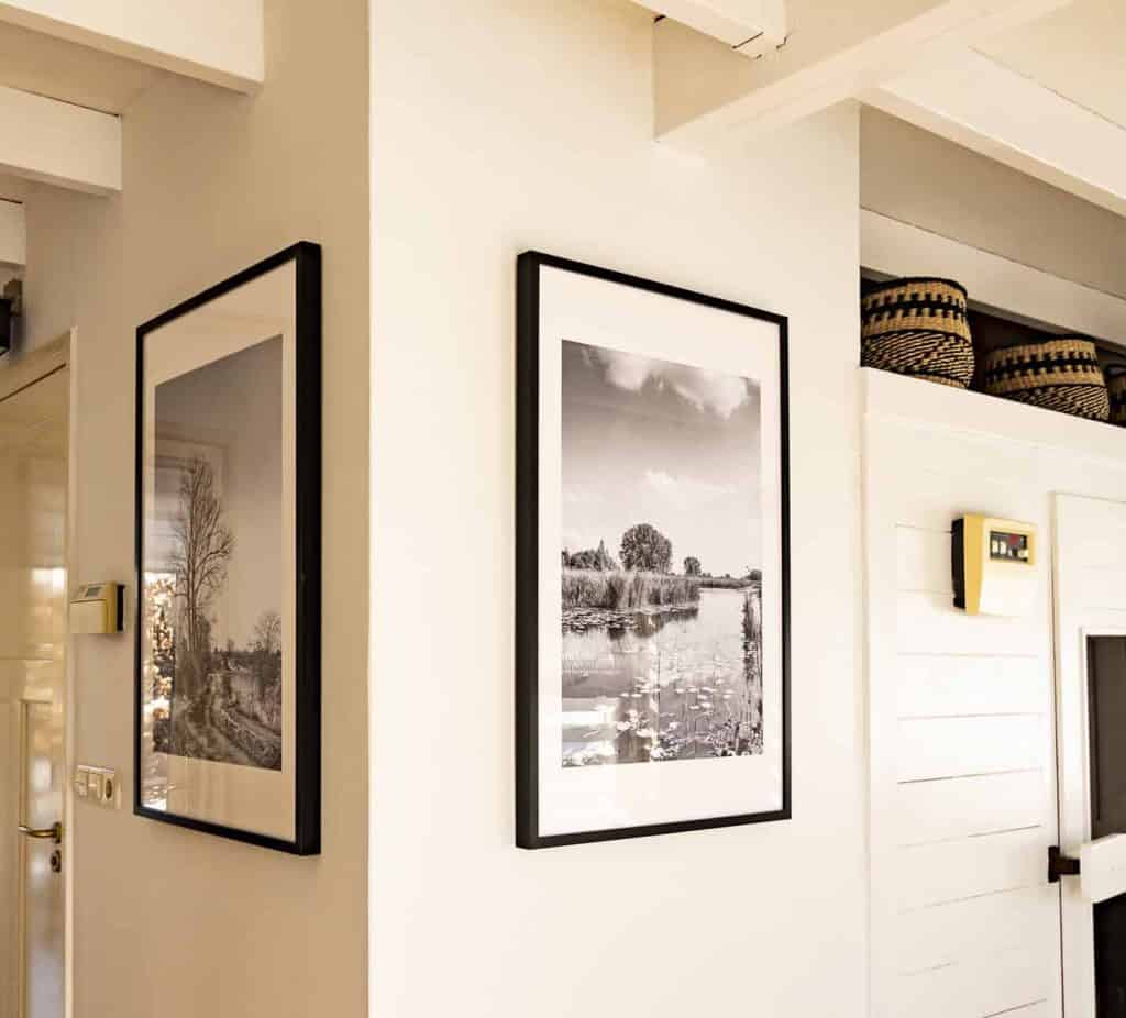 Zwart-wit landschap foto in modern interieur met witte muren en decoratieve manden.