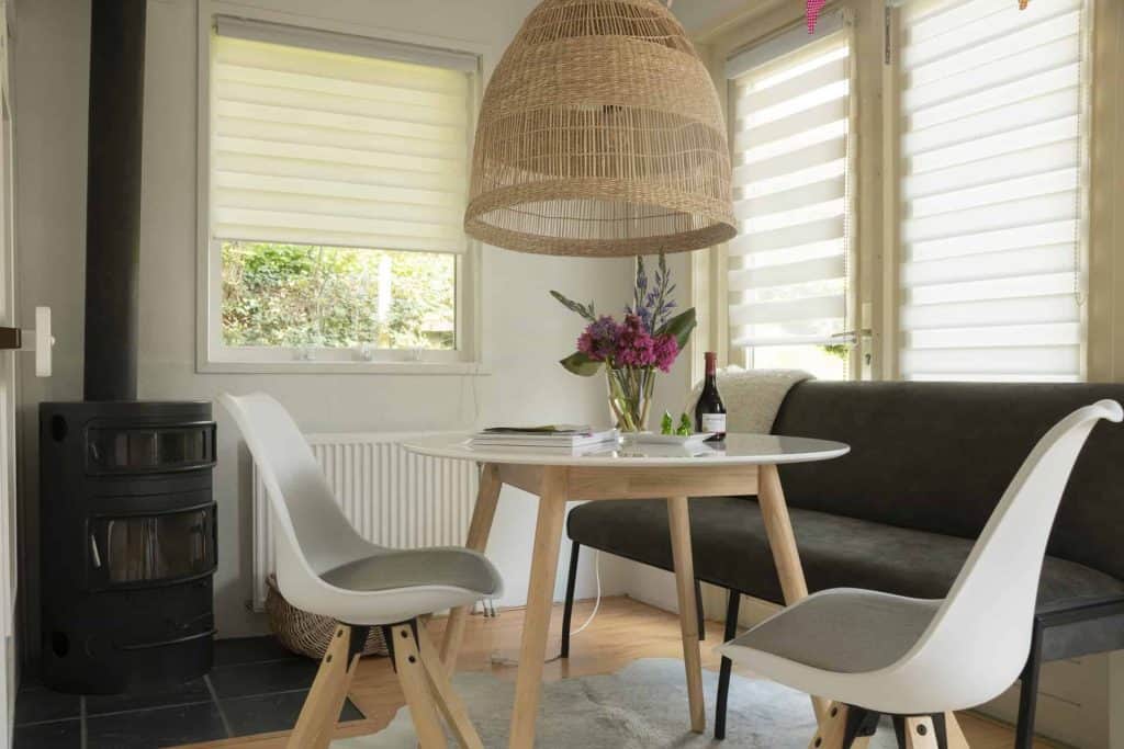 Gezellige eethoek met tafel, stoelen en bloemen op 't Gelders Eiland, rustiek interieur met natuurli.