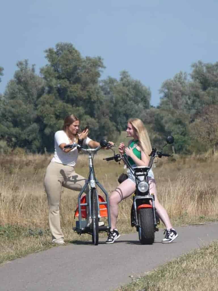 Gezin met twee jonge vrouwen op elektrische fietsen in de natuur op 't Gelders Eiland.
