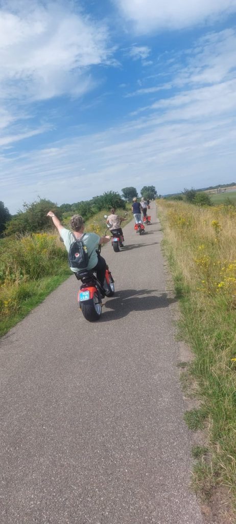 Groep mensen op e-bikes fietsen langs het landschap op 't Gelders Eiland.