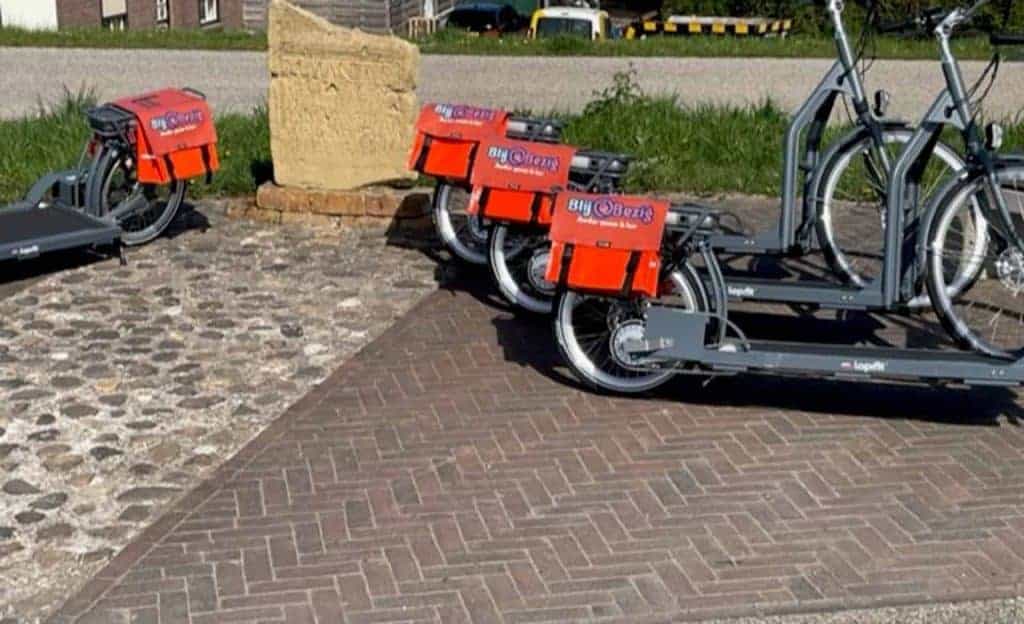 E-scooters geparkeerd op 't Gelders Eiland, fietspad en historische omgeving.