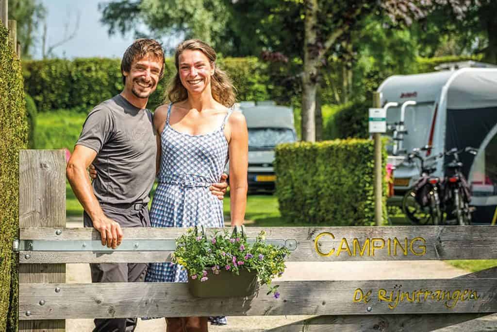 Gezellige kampeerders bij camping 't Gelders Eiland, omgeven door groen en natuur in Gelderland.