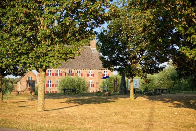 Traditioneel dorpshuis met rieten dak en kleurrijke ramen op 't Gelders Eiland.