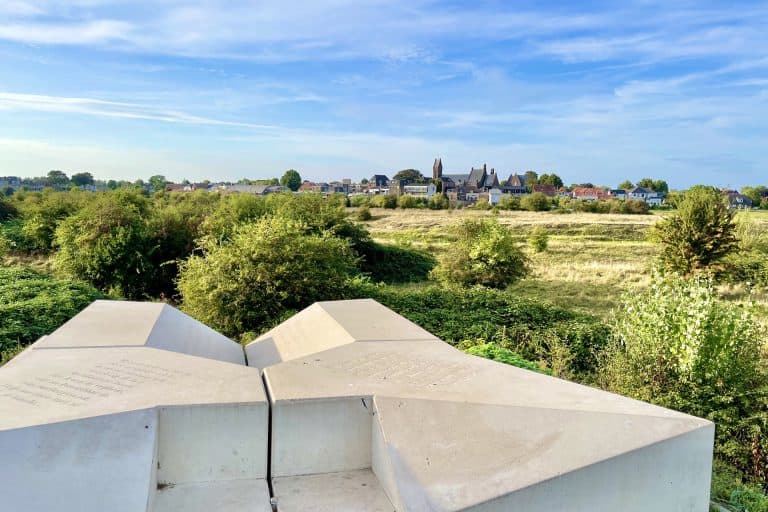 Moderne witte sculptuur op 't Gelders Eiland met uitzicht op het platteland en de stad op de achterg.