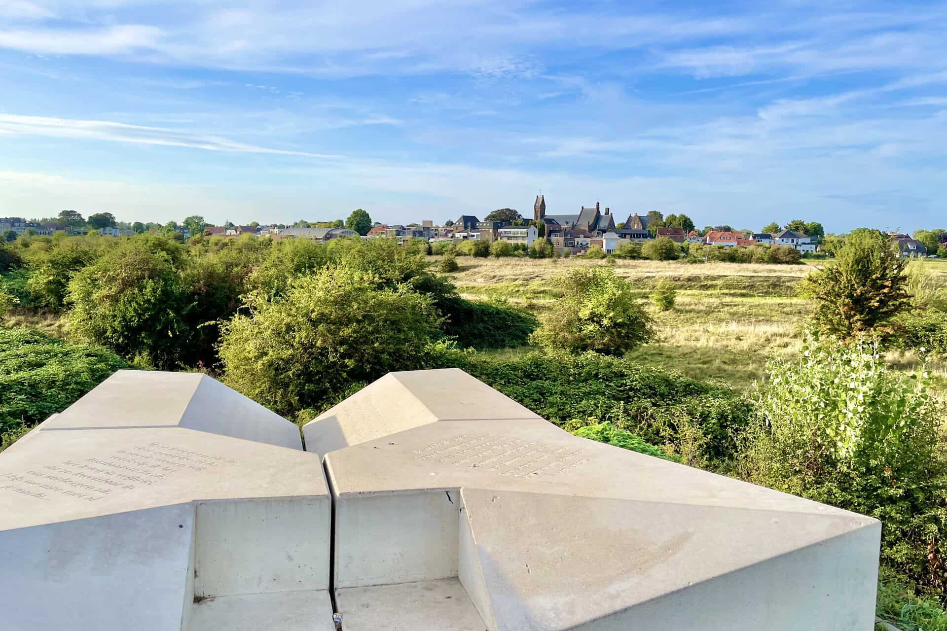 Moderne witte sculptuur op 't Gelders Eiland met uitzicht op het platteland en de stad op de achterg.