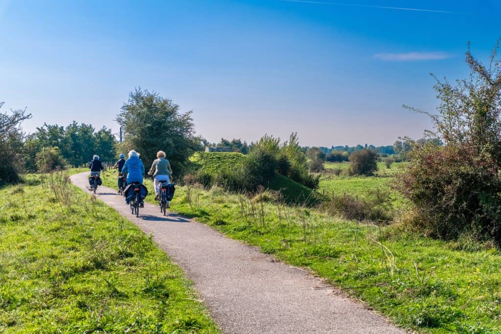 Fietsen op 't Gelders Eiland langs groene natuur en heldere blauwe hemel.