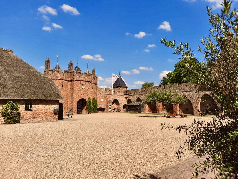 Kasteel op 't Gelders Eiland met middeleeuwse architectuur en omringende tuin, een populaire toerist.