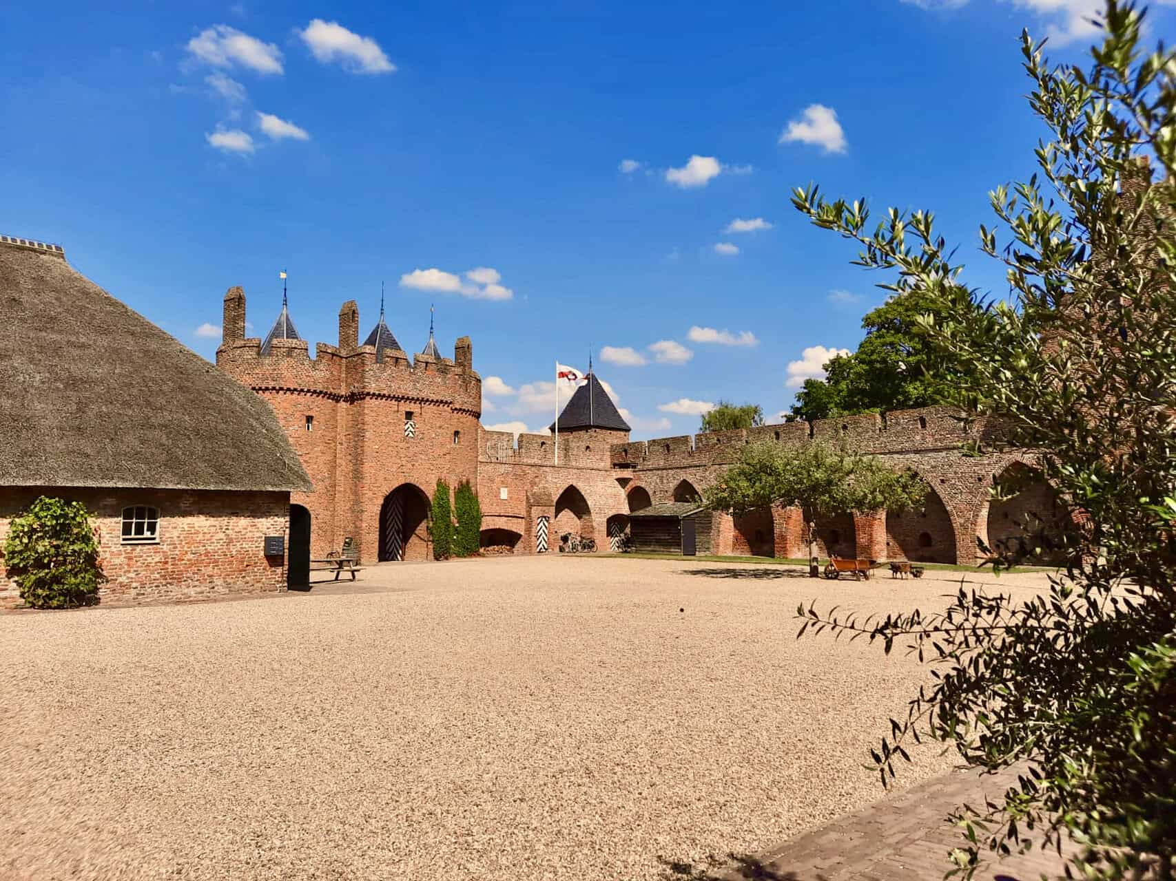 Kasteel op 't Gelders Eiland met middeleeuwse architectuur en omringende tuin, een populaire toerist.