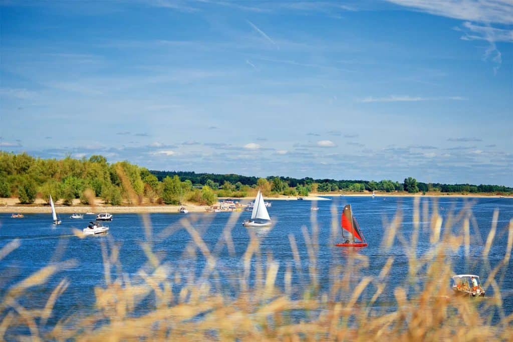 Zomer op 't Gelders Eiland met zeilboten en blauwe hemel.