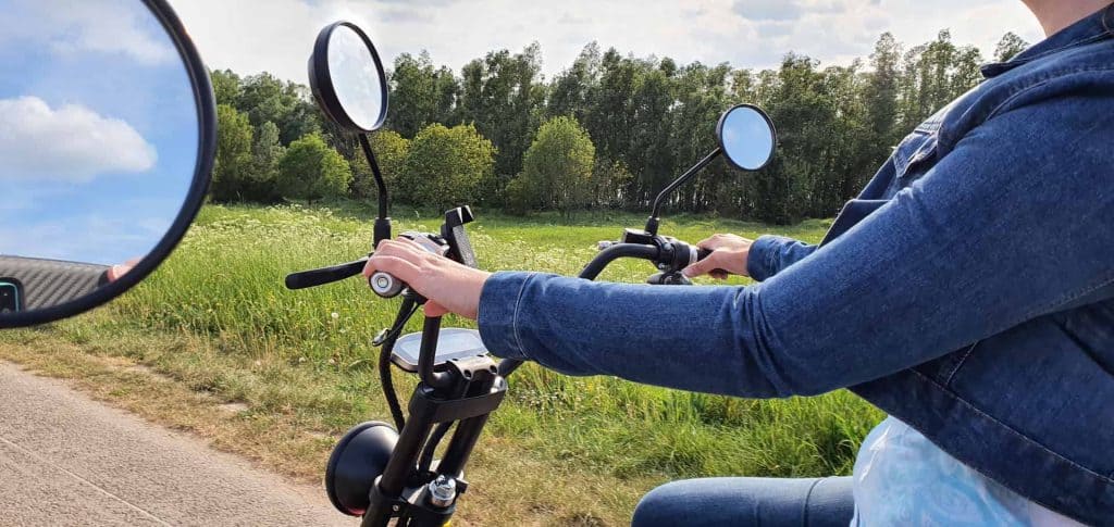 Fietser op een landelijke weg op 't Gelders Eiland met groene natuur en blauwe lucht.