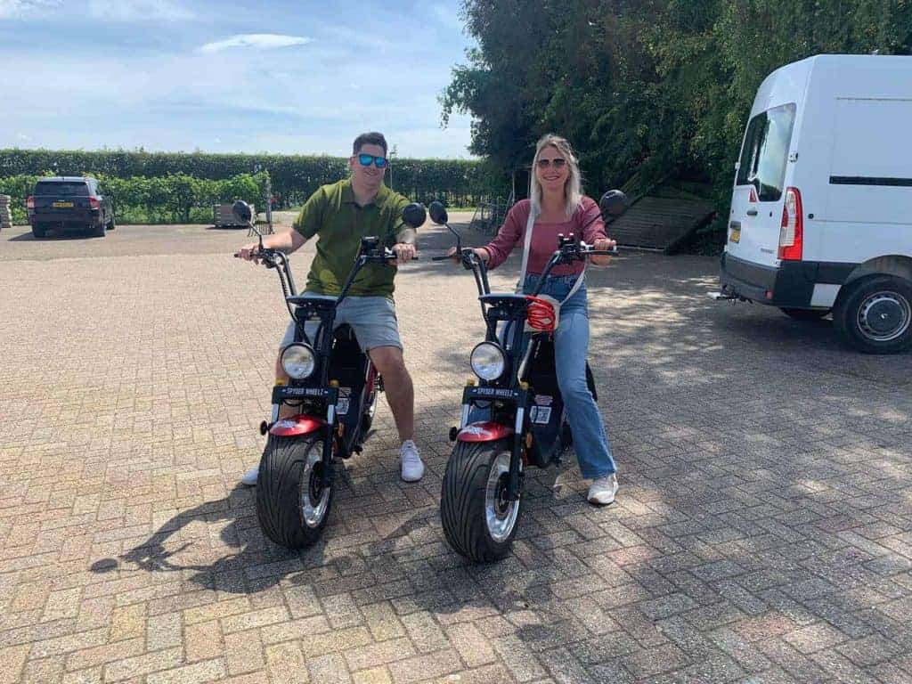 Twee mensen op elektrische scooters op 't Gelders Eiland, genietend van de omgeving.