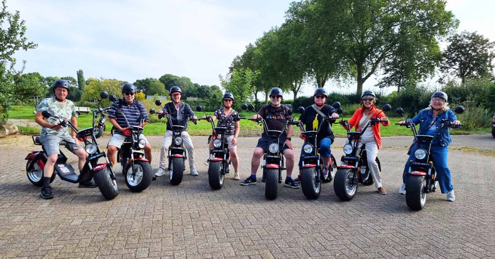Groep mensen op elektrische scooters op 't Gelders Eiland in de buitenlucht.