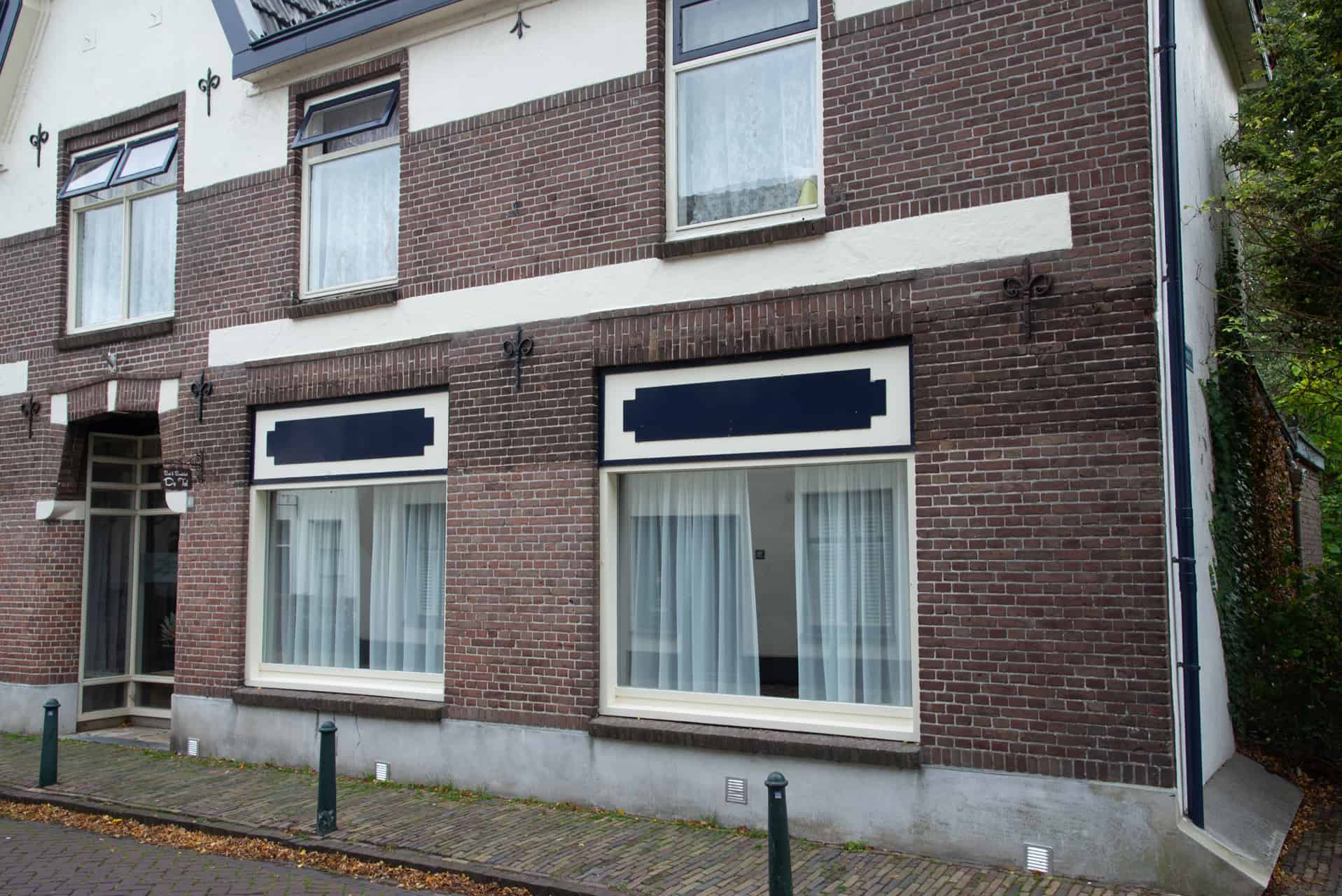 Huis met grote ramen en witte gordijnen aan de straatzijde op ’t Gelders Eiland.