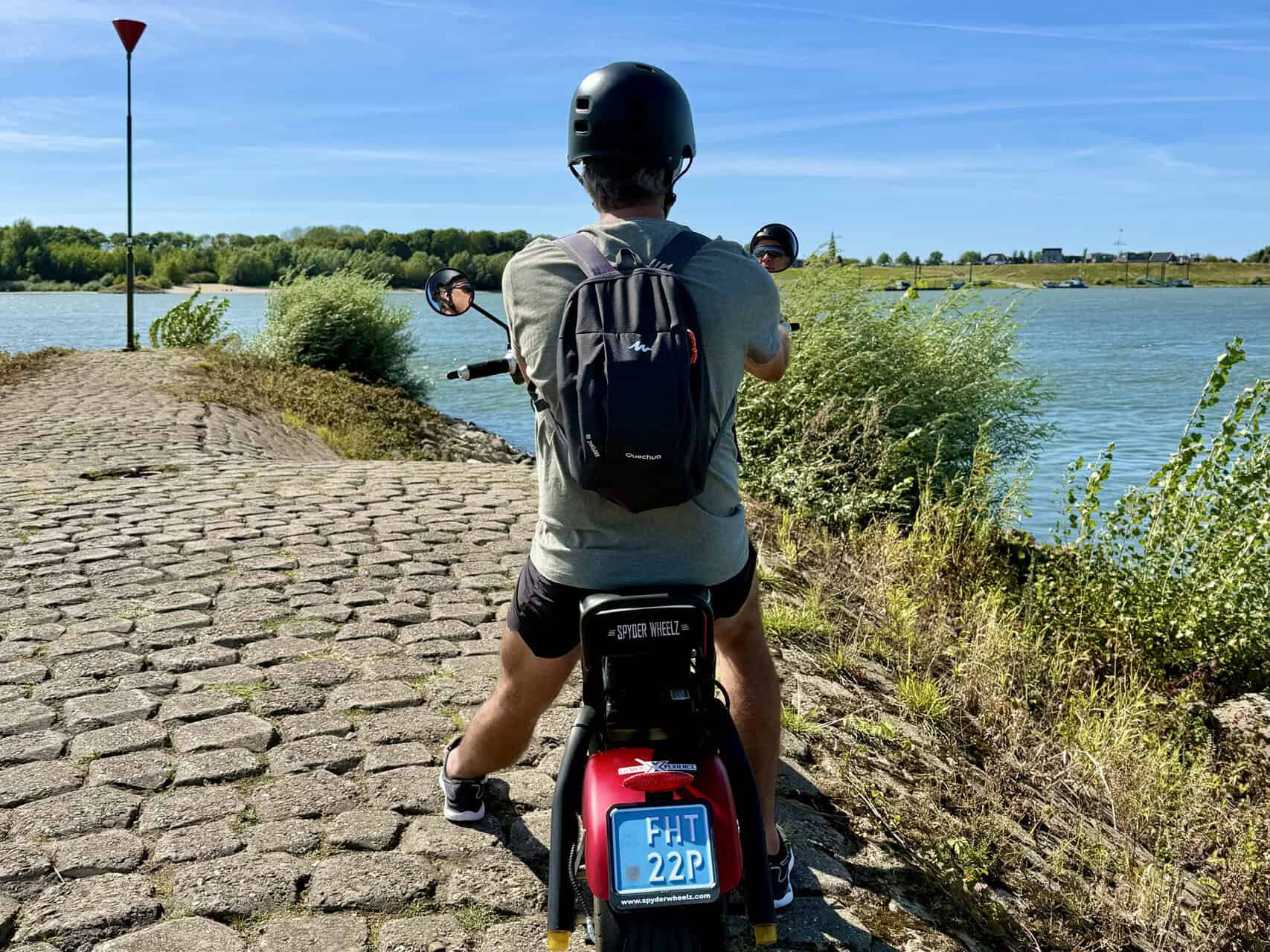 Fietser op 't Gelders Eiland met uitzicht op rivier, genietend van de natuur en het water.
