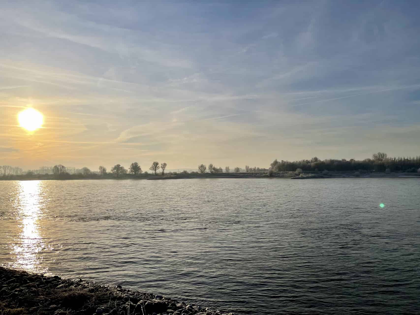 Zonsondergang over 't Gelders Eiland, rustige rivier en open hemel.
