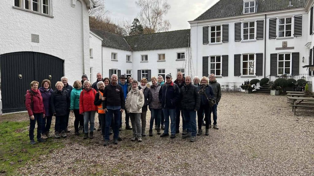 Heren en dames groep op 't Gelders Eiland voor historische gebouwen en landschap.