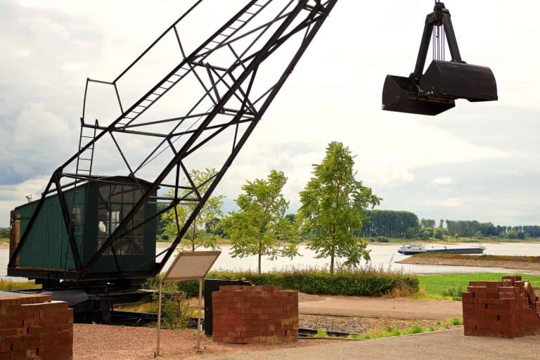 Oude industriële kraan met hijsarm en bak, gelegen aan de rivier op 't Gelders Eiland.
