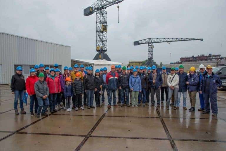 Groep mensen met helmen op bouwplaats op 't Gelders Eiland, onder grote bouwkranen.