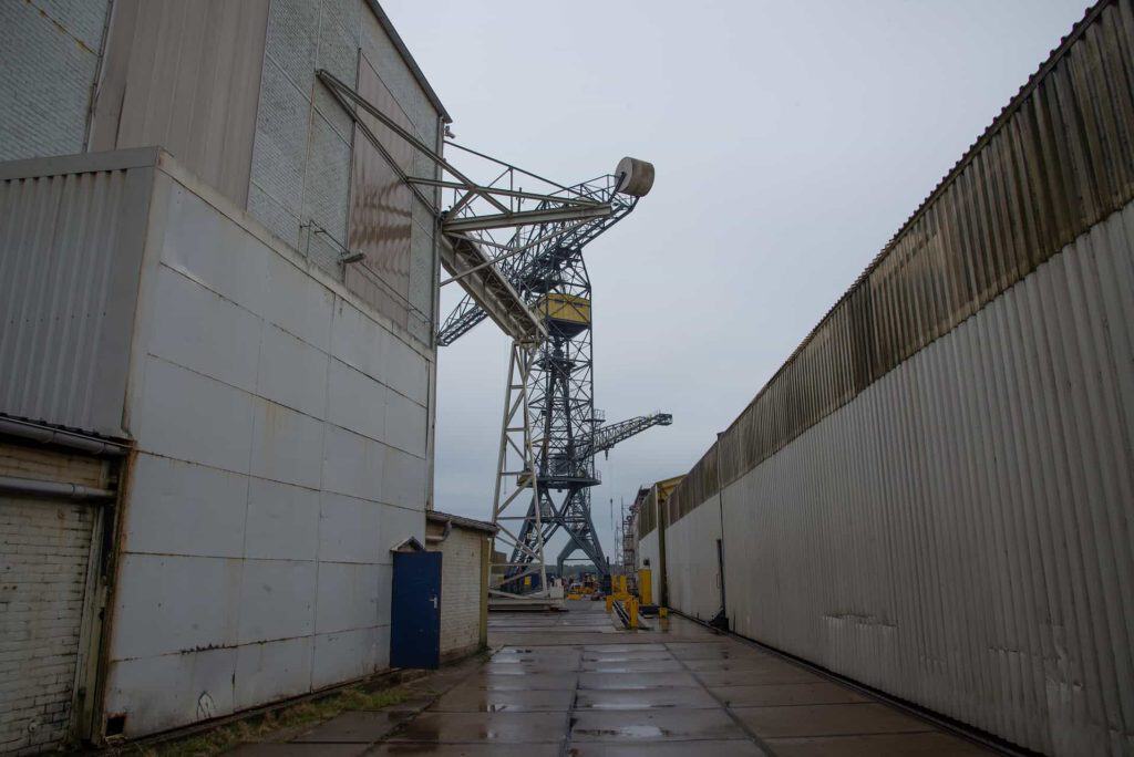 Havenkraan op 't Gelders Eiland met industriële gebouwen en een natte weg.