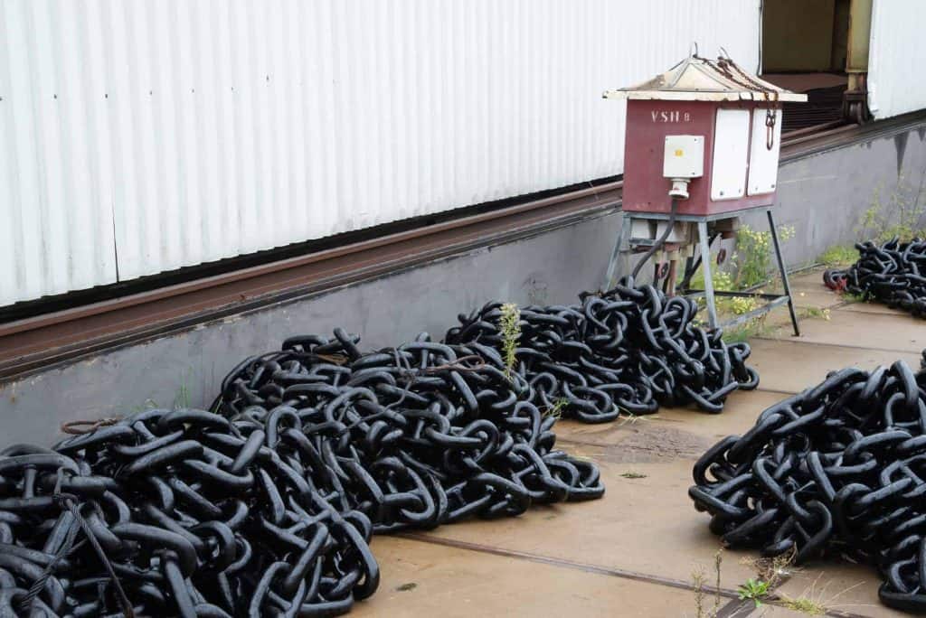 Zwarte kettingen op de kade bij 't Gelders Eiland, mogelijk voor scheepvaart of havengebruik.