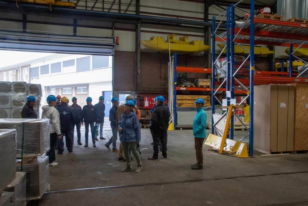Veiligheidstraining in een magazijn op 't Gelders Eiland, met werknemers en veiligheidsinstructies.
