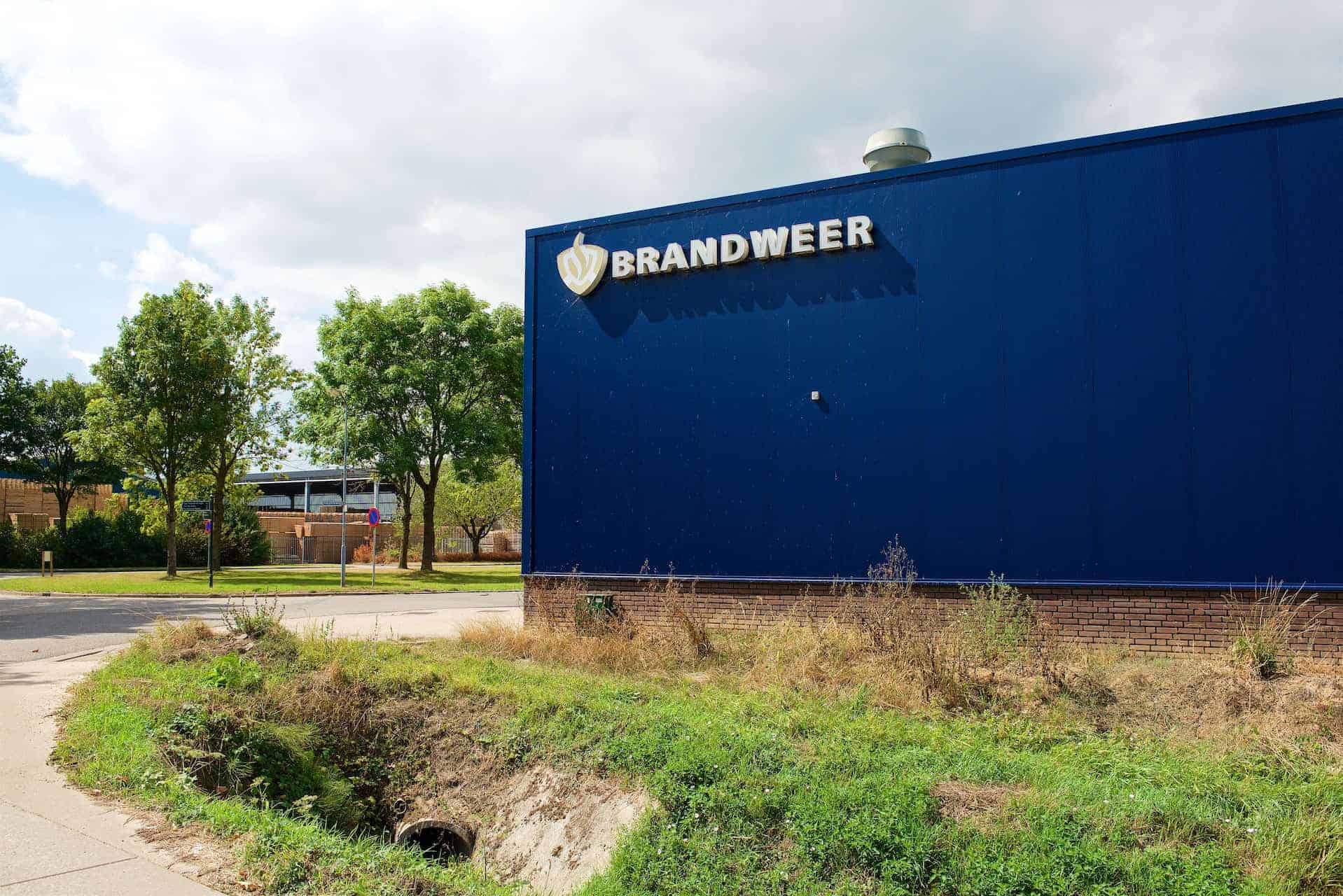 Brandweergebouw op 't Gelders Eiland met blauwe gevel en logo.