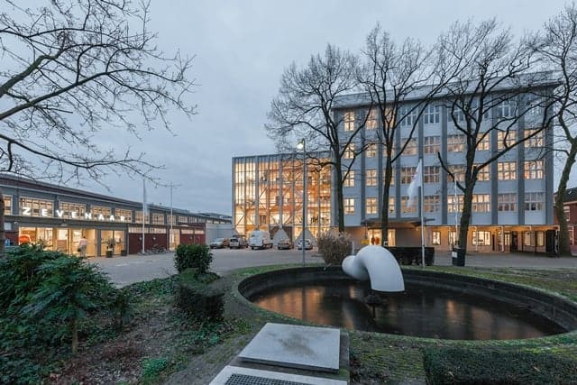 Modern appartementencomplex met waterpartij en sculptuur op 't Gelders Eiland.