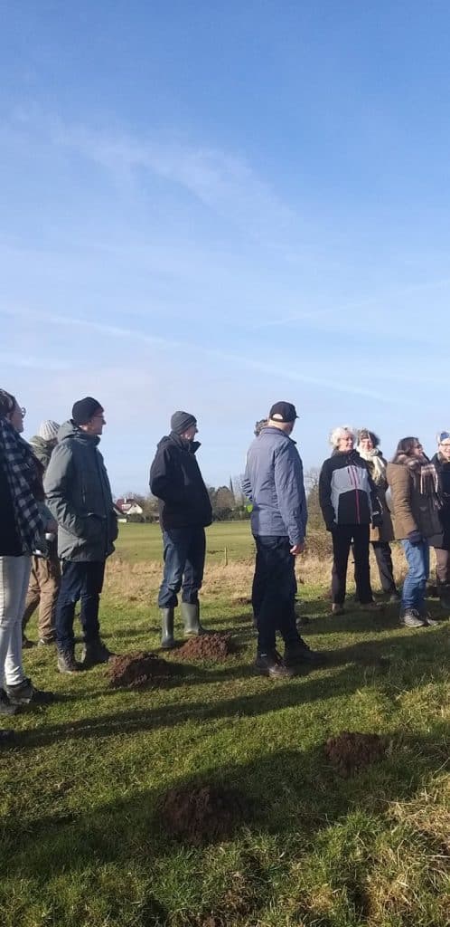 Gezelschap wandelaars op 't Gelders Eiland onder een heldere blauwe hemel.