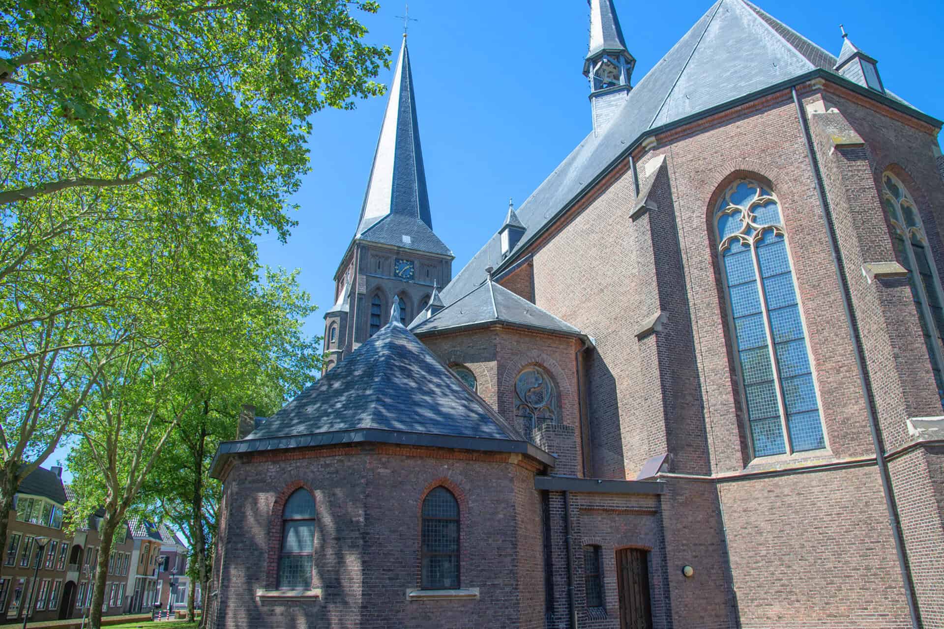 Historische kerk met hoge torens en grote ramen op 't Gelders Eiland.