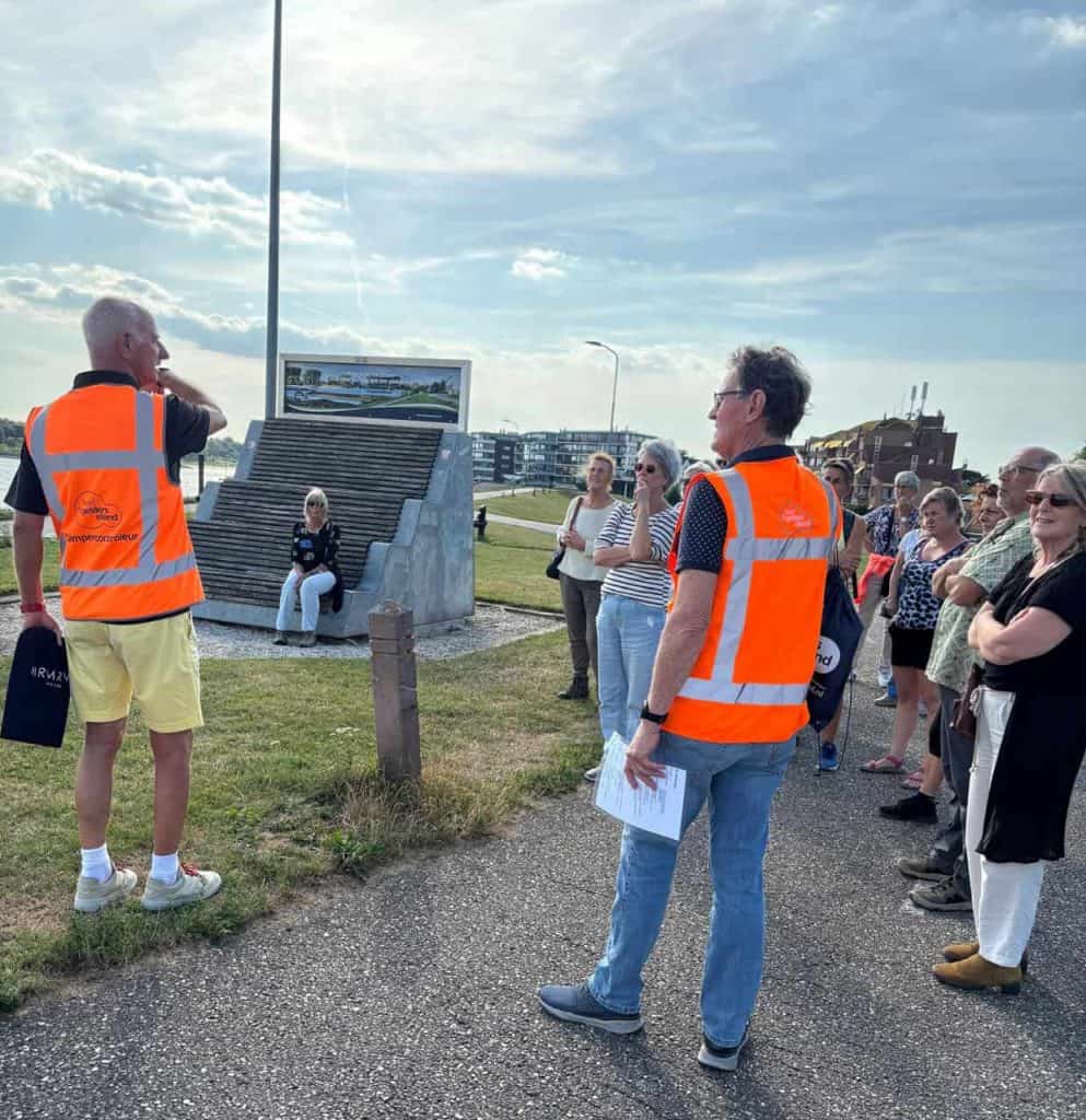 Veiligheidsgidsen geven uitleg aan toeristen op 't Gelders Eiland over de omgeving.